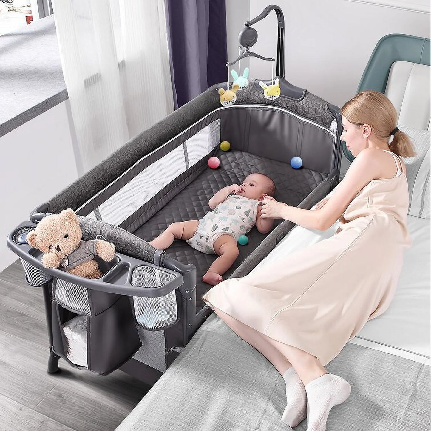 Babybond 3-in-1 Bedside Bassinet, Play Yard & Diaper Changer, suitable for newborns to toddlers aged 0-2. Comes with mattress, mosquito net, bottom diaper storage compartment and toy bar.Grey